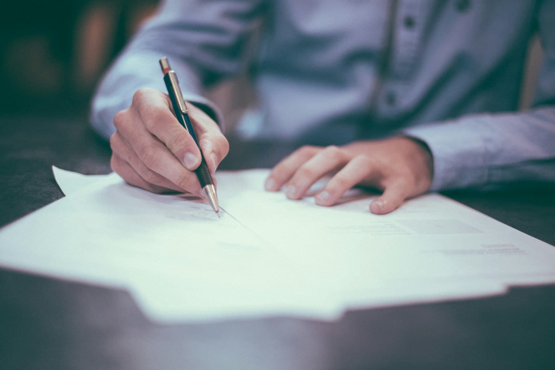 A person signing a printed document